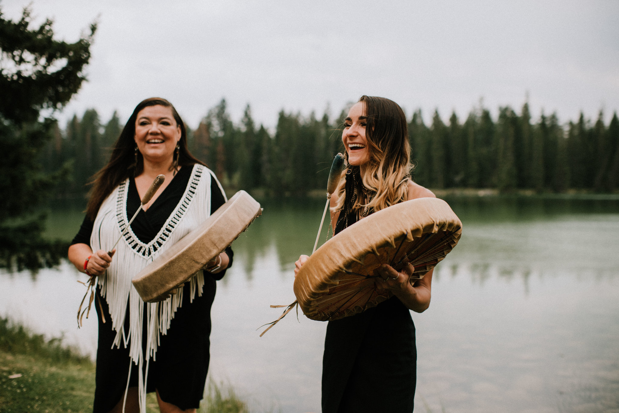 Mackenzie is drumming in front of a lake with her mom Matricia