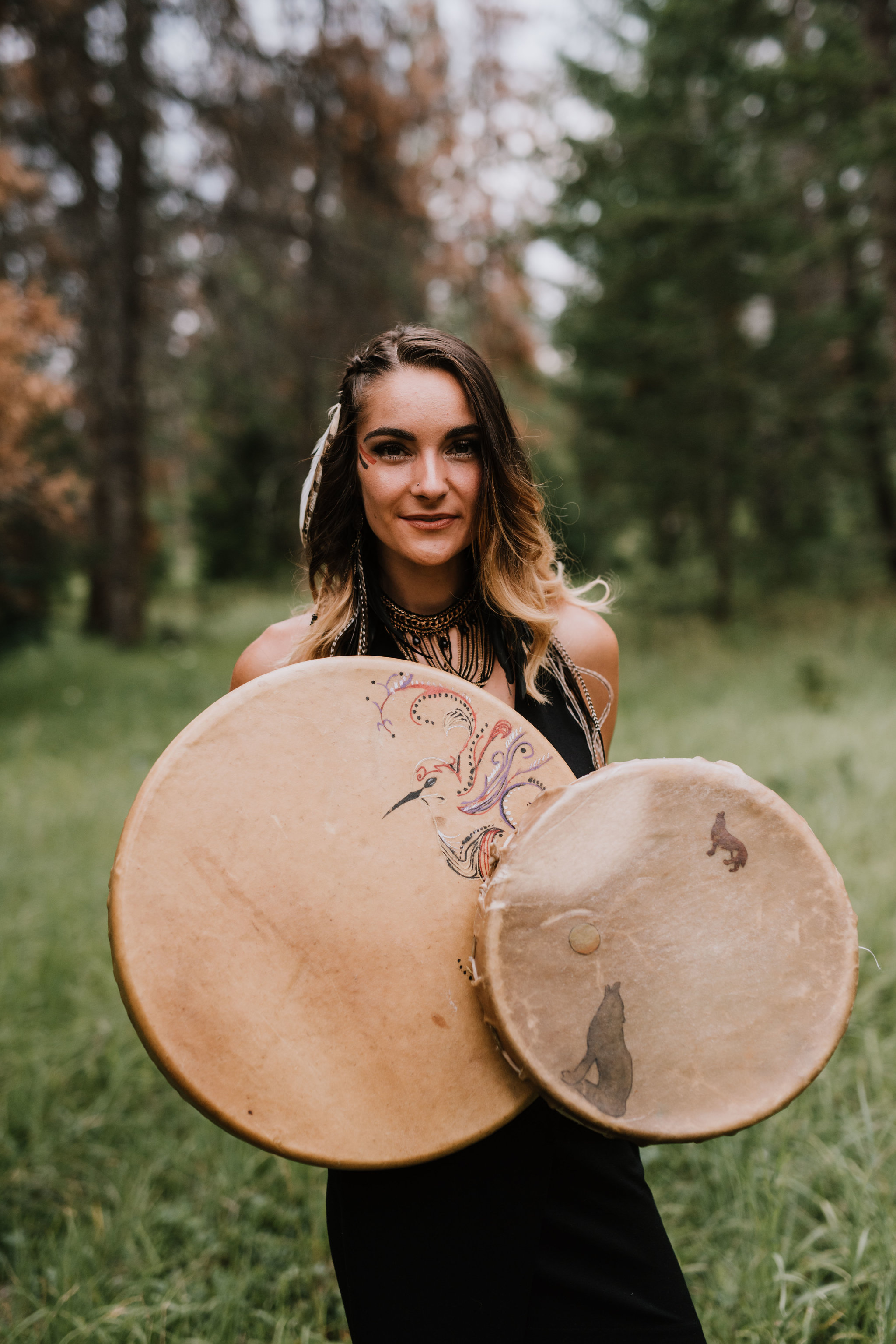 mackenzie brown holding her drums in a forest