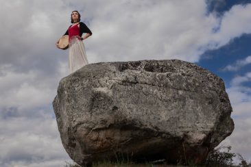 Mackenzie Brown on a rock with her drum